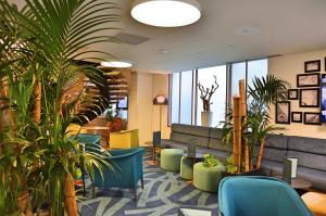 a lobby with chairs and plants in a building at Mercure Toulouse Centre Saint-Georges in Toulouse