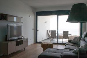 アルカイデサにあるLuxury Apartment Sea, Golf and Gibraltar Viewのリビングルーム(ソファ、薄型テレビ付)