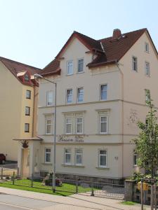 a large white building on the side of a street at Pension Der kleine Nachbar in Gotha