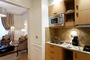 a kitchen with a stove and a microwave at Majestic Hotel Spa - Champs Elysées in Paris