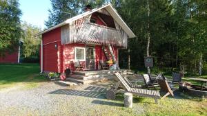 a red cabin with a bench in front of it at Maatilamatkailu Ilomäki in Peräseinäjoki