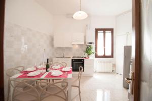 een witte keuken met een tafel en stoelen. bij Riva Excelsior Apartment in Venetië