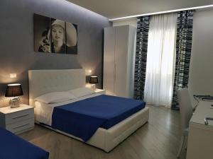 a bedroom with a blue and white bed and a window at Domus Barberini in Rome
