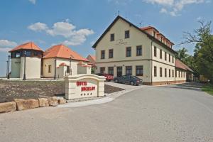 a building with a sign in front of a street at Hotel Buchlov in Buchlovice