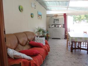 a living room with a brown couch with red pillows at Armalou in Pouilly-sur-Loire