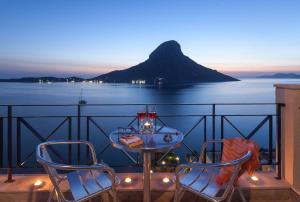 een tafel en stoelen op een balkon met uitzicht op de oceaan bij Ambiance Studios in Masouri