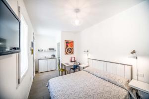 ein weißes Schlafzimmer mit einem Bett und einem Schreibtisch in der Unterkunft Locazione Turistica Duca d'Aosta 31 in Mestre