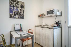 eine Küche mit Spüle, Tisch und Mikrowelle in der Unterkunft Locazione Turistica Duca d'Aosta 31 in Mestre
