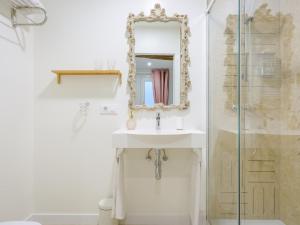 a white bathroom with a sink and a mirror at HABITAKA, Hogares de paso in Vitoria-Gasteiz