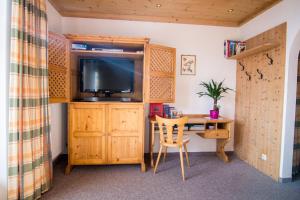 a room with a desk and a tv and a table at Hof Hamoos in Kitzbühel