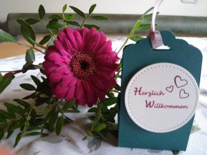 una flor rosa junto a una tarjeta azul con una flor en Haus Hubert, en Arzl im Pitztal