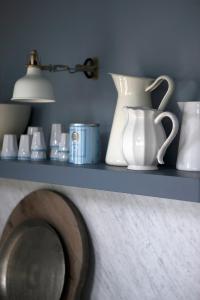 a shelf with white vases and a lamp on it at Black timber house in Borgarnes