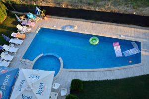 an overhead view of a swimming pool with chairs and a ball at Club Priz in Primorsko