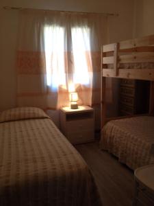 ゴルフォ・アランチにあるvilla aranciのベッドルーム1室(ベッド2台、ナイトスタンドのランプ付)