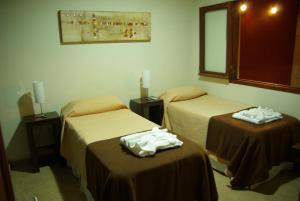 a hotel room with two beds with towels on them at Hotel Urbana in Cordoba