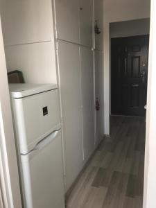 a kitchen with a white refrigerator and a hallway at PanoramaPanel in Budapest