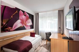 una habitación de hotel con una gran flor rosa en la pared en Mark Apart Hotel, en Berlín