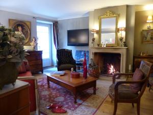 a living room with a table and a fireplace at La Mirandole in Foix