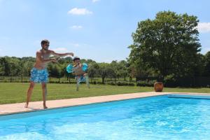 Un uomo che gioca con un frisbee in piscina di Holiday Home Château de Boucéel Mont Saint Michel a Vergoncey