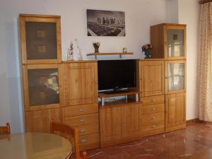 a large wooden entertainment center with a flat screen tv at Balcon del mar in El Morche