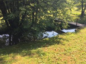 a stream of water with a bridge in a field at Apartma 5 in Radovljica +1 photo