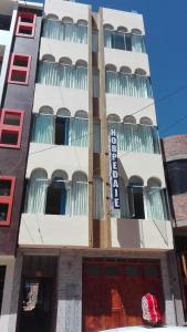 a tall white building with a sign on it at Hostel Puno Backpackers in Puno