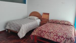 a hotel room with two beds and a bedskirts at Hostel Puno Backpackers in Puno