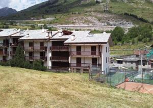 een gebouw op een heuvel met een tennisbaan bij Isa in La Thuile