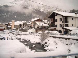 een stad bedekt met sneeuw met een rivier en huizen bij Isa in La Thuile