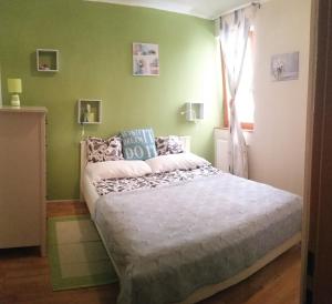 1 dormitorio con cama y pared verde en Downtown Garden Isle in urban Style-Free parking en Budapest