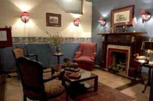 a living room filled with furniture and a fire place at Hotel Isla Rey Jorge in Punta Arenas