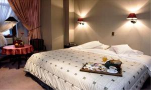 una habitación de hotel con una bandeja de comida en una cama en Hotel Isla Rey Jorge, en Punta Arenas