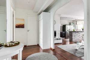 a kitchen and living room with white walls and wood floors at Apartment Pohjantähti in Oulu