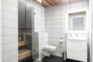 a white bathroom with a toilet and a sink at Apartment Pohjanpoika in Oulu +11 photos