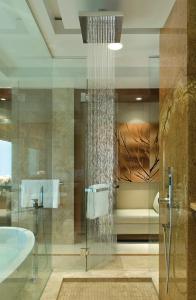 a bathroom with a glass shower and a tub at Four Seasons Hotel Denver in Denver