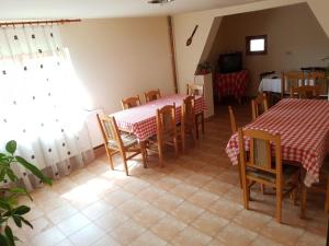 una sala da pranzo con due tavoli, sedie e una televisione di Cabana Suciu a Răchiţele Altre 13 foto