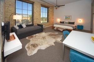 a living room with a couch and a bed and a rug at Kinn Guesthouse Bay View in Milwaukee