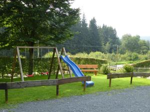 einen Spielplatz mit einer blauen Rutsche und einer Bank in der Unterkunft Haus Sonnentau in Monschau