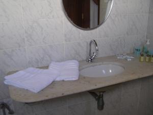 y baño con lavabo, espejo y toallas. en Pousada da Mércia - Itapuã (BA), en Salvador