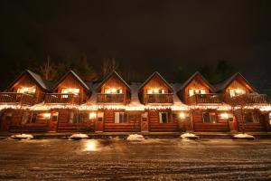 eine Blockhütte mit Weihnachtslichtern in der Unterkunft Nootka Lodge in Woodsville