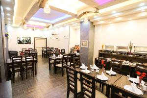 a restaurant with tables and chairs in a room at 7Boys Hotel in Amman