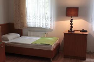 a small bedroom with a bed and a lamp at Dom Sonata in Gdańsk