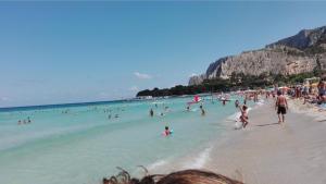 eine Gruppe von Menschen im Wasser an einem Strand in der Unterkunft Halley House in Mondello