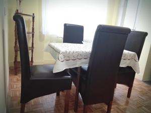 einem Esstisch mit 2 Stühlen und einem Tisch mit einer Tischdecke in der Unterkunft Apartment Jelena in Belgrad