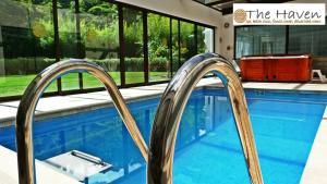 una piscina con barandillas metálicas en una casa en The Haven - Hotel & Spa, Health and Wellness Accommodation - Adults Only, en Boquete