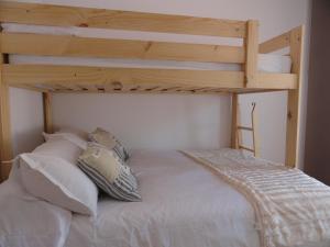 ein Schlafzimmer mit einem Etagenbett mit weißen Kissen in der Unterkunft Apartamento Terrazas de Monachil in Monachil