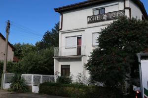 a white house with a sign on the side of it at Hostel Trajan in Donji Milanovac