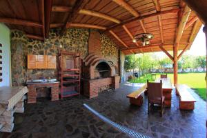 an outdoor patio with a fireplace and a table and chairs at Pensiunea la Nise in Sîmbăta de Sus