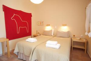 two beds in a room with a red painting of a horse at Myrtia Apartments in Divarata