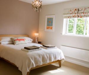 a bedroom with a bed with a chandelier and a window at Walton Crescent in Winford